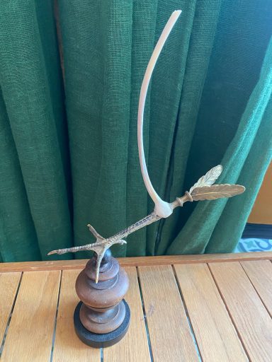 Cabinet de curiosité - Hermès Sculpture d'une pâte d'oiseau prolongée de 2 ailes en laiton doré et surmontée d'une côte monté sur socle circulaire en bois.